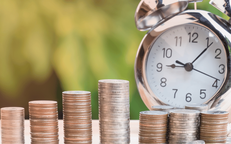 Horloge et pièces de monnaie, représentant l'investissement dans une assurance santé pour la sécurité financière à long terme