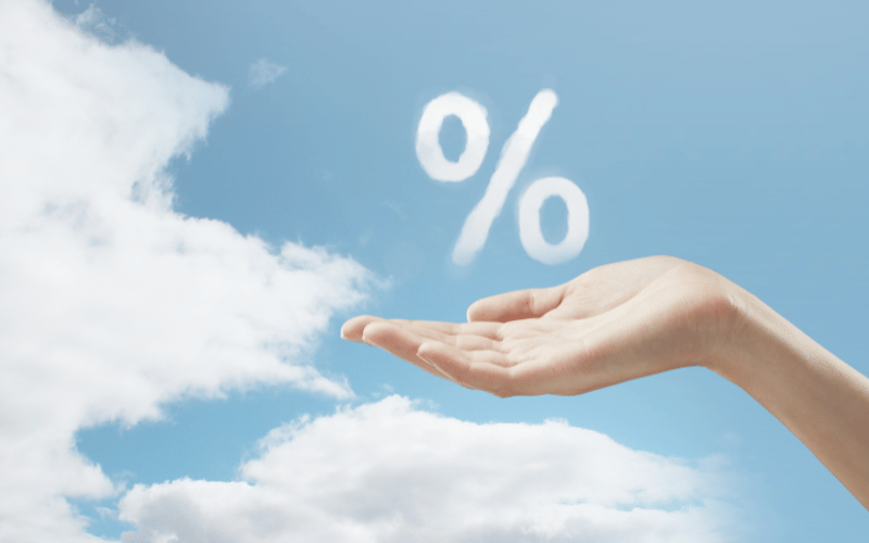 Nuage en forme de pourcentage au-dessus d’une main, symbolisant le taux de couverture d’une assurance emprunteur